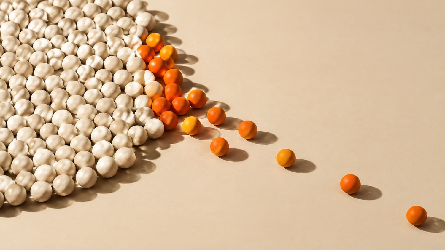 A dense field of small bone-white spheres on a bone paper sweep, with a narrow band of orange ones breaking away from the edge of the group across open paper.